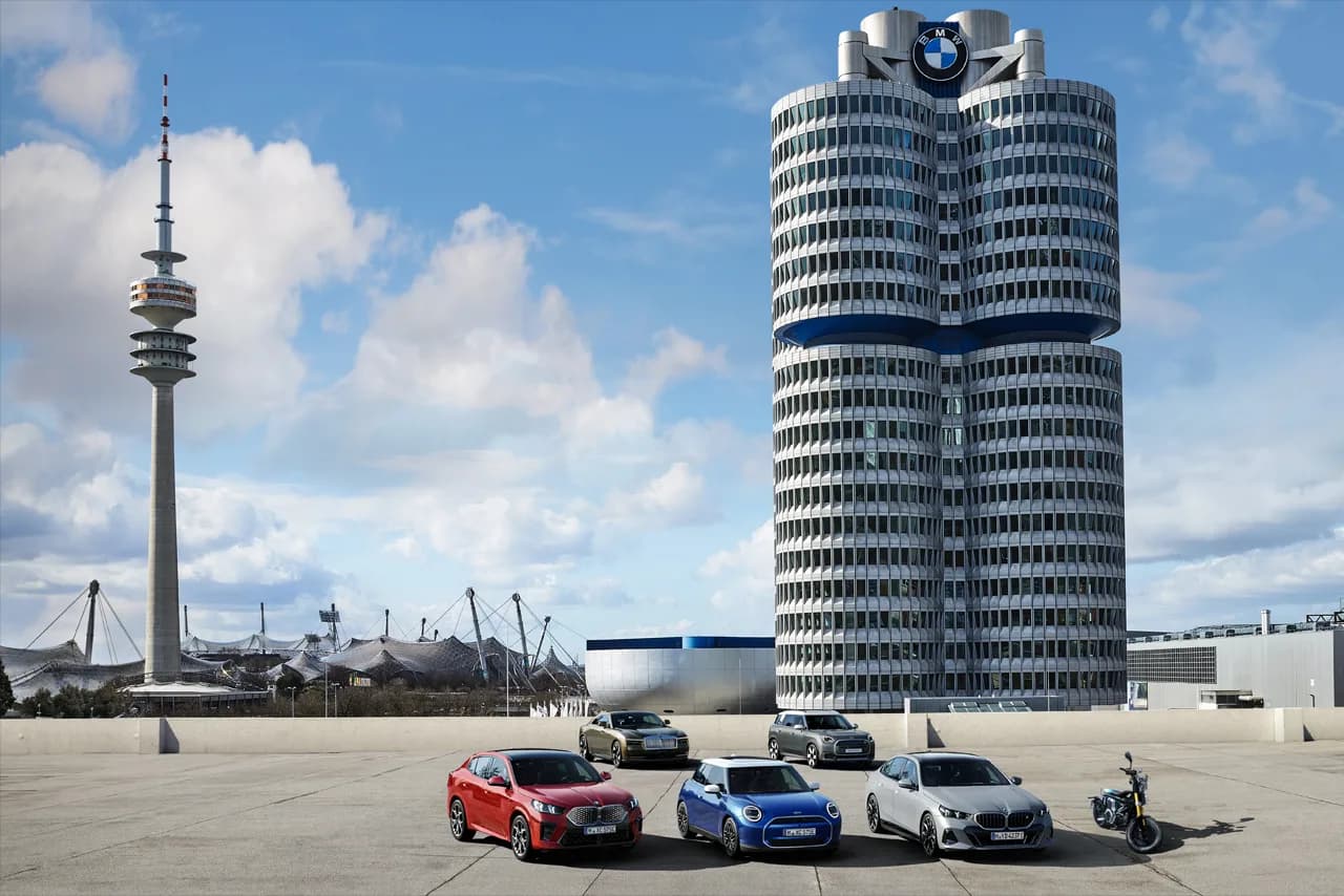 BMW headquarters tower in Munich beside a lineup of the group's vehicles