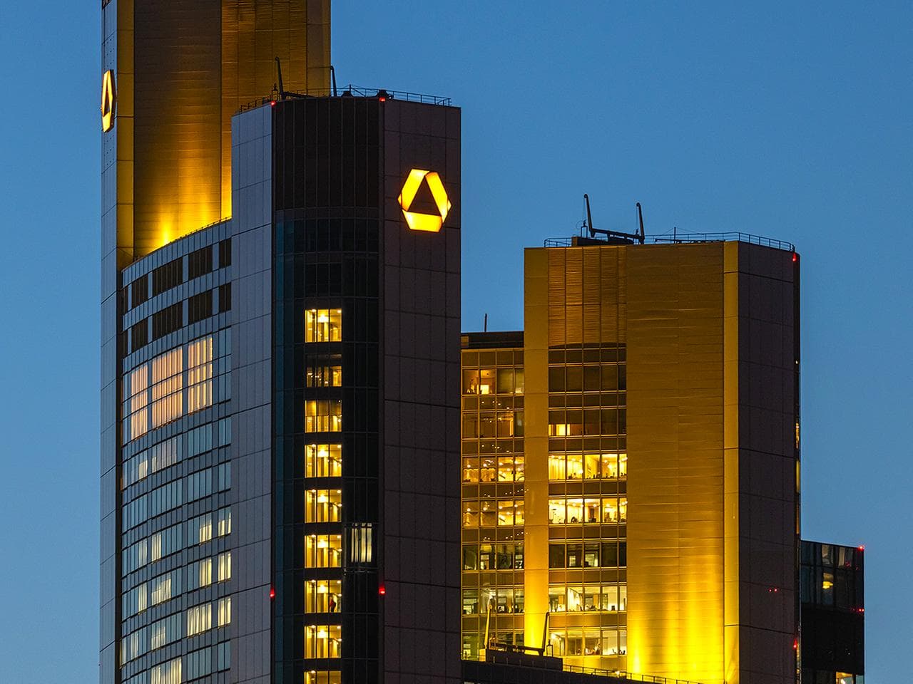 The illuminated Commerzbank headquarters towers in Frankfurt at dusk