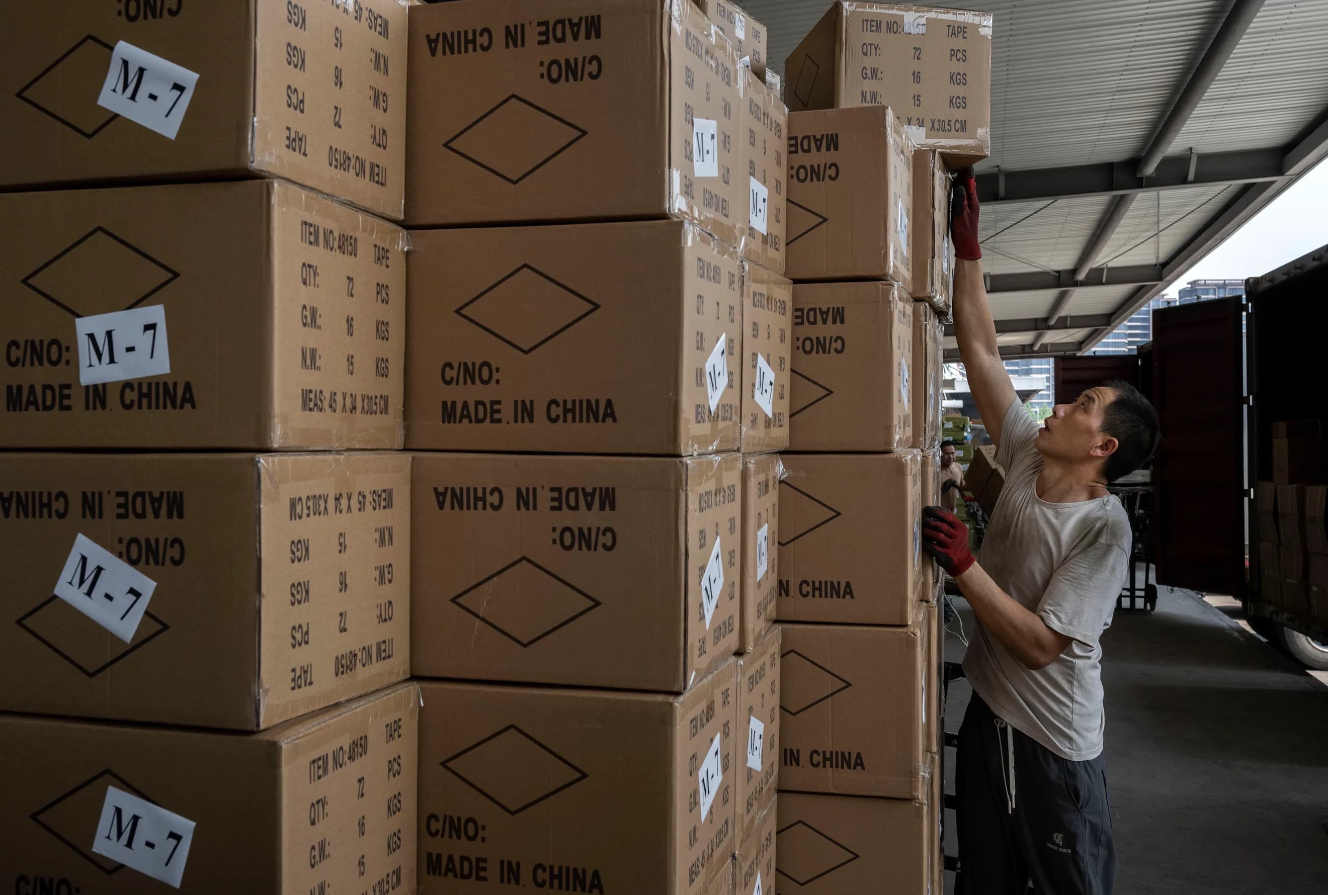 A worker stacks boxes marked Made in China at a shipping warehouse