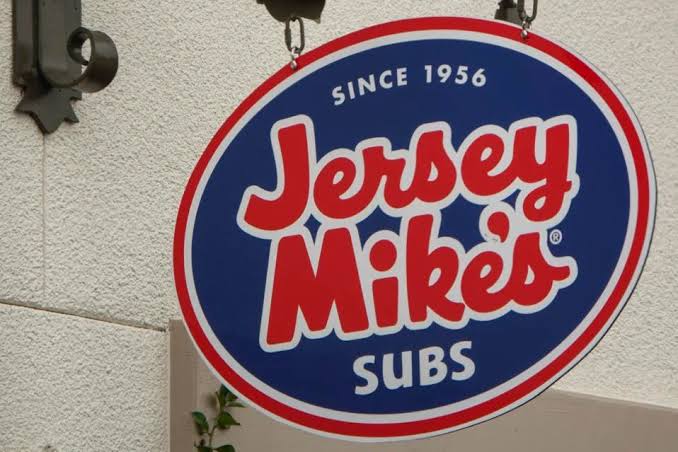 A Jersey Mike's Subs sign hanging outside a storefront