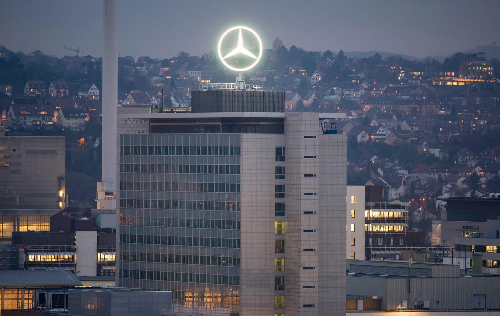 The illuminated Mercedes-Benz star atop the company headquarters in Stuttgart at dusk