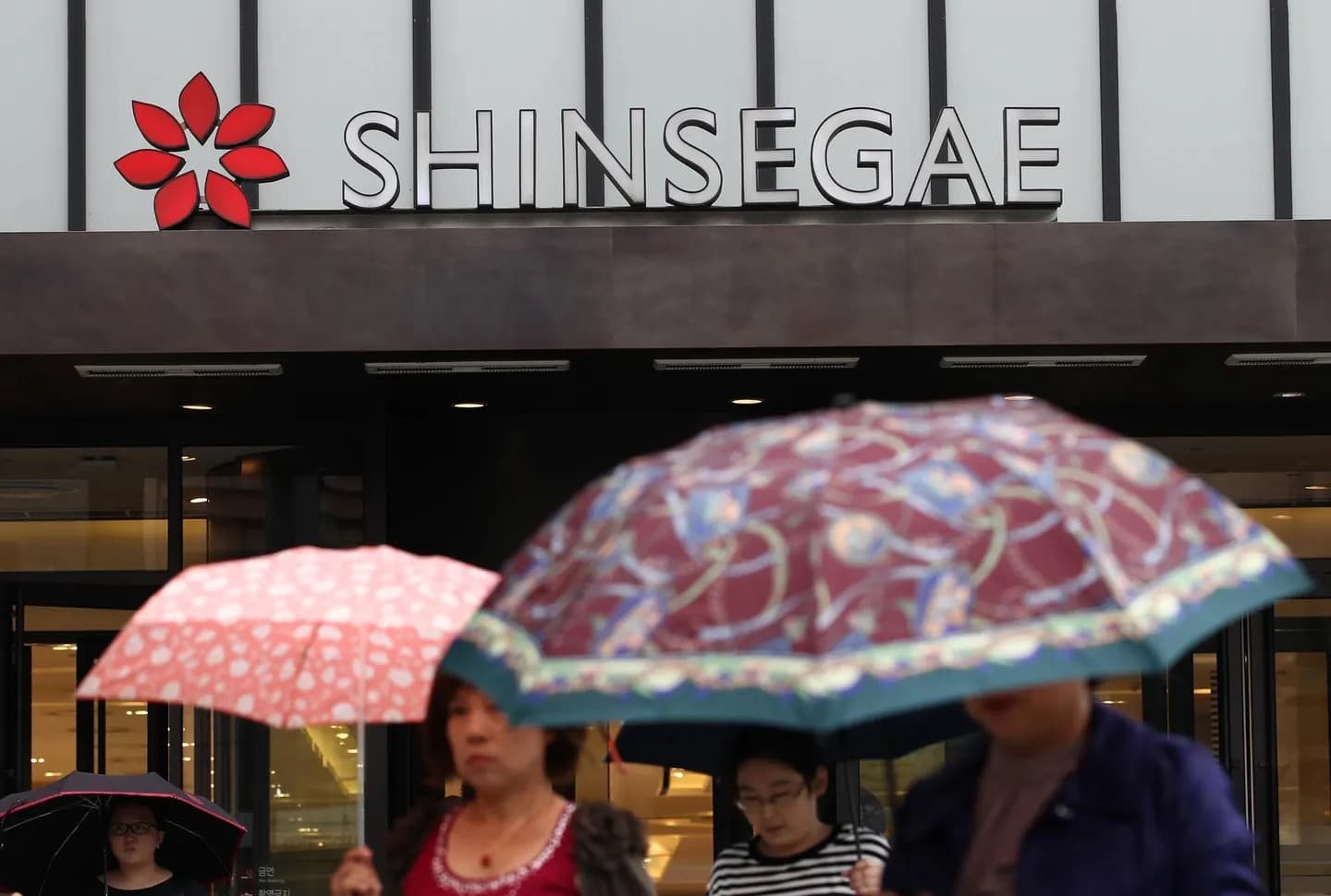 Shoppers with umbrellas outside a Shinsegae department store in South Korea