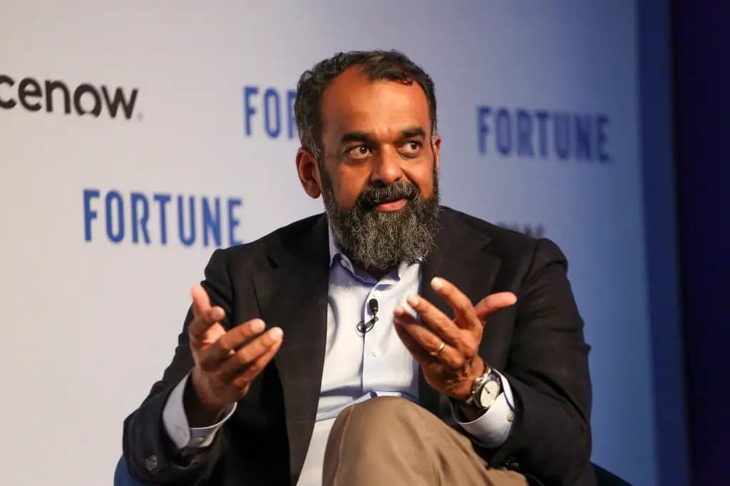 Suresh Venkatarayalu gesturing with both hands while seated on a Fortune conference stage